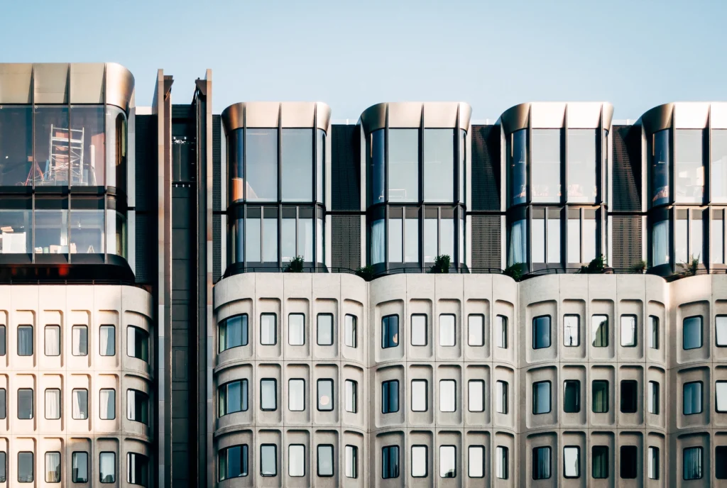A beautiful wide shot of modern white architecture with large glass windows under a clear blue sky