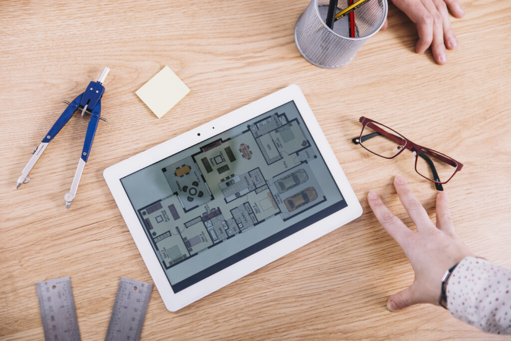 crop-hands-near-tablet-with-plan