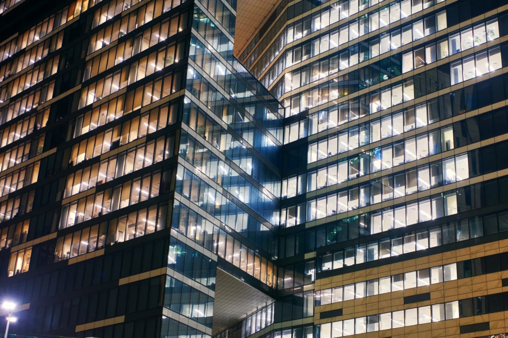 Skyscrapers windows of Moscow-city downtown business center with tall buildings at night. Illuminated windows of business office center. Late night overtime in a modern office building.