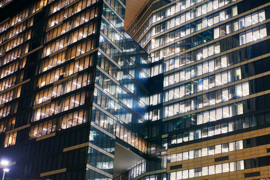 Skyscrapers windows of Moscow-city downtown business center with tall buildings at night. Illuminated windows of business office center. Late night overtime in a modern office building.