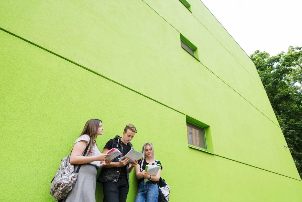 students-posing-outside-college-building